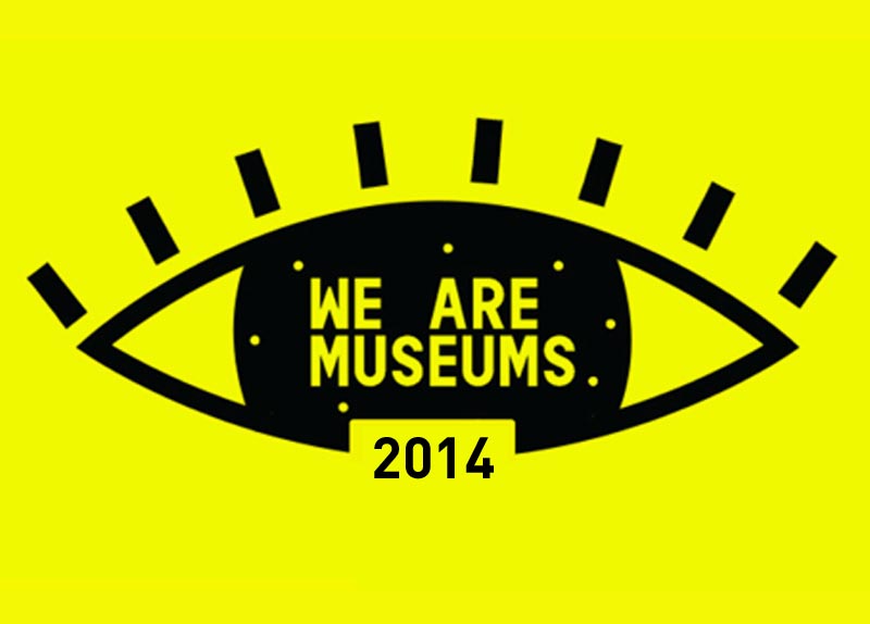 L'image représente un œil stylisé de couleur noire sur un fond jaune vif. À l'intérieur de l'œil, on peut lire l'inscription "WE ARE MUSEUMS" en lettres blanches. En dessous, l'année "2014" est écrite en noir. Le design est moderne et graphique, attirant l'attention grâce à ses couleurs contrastées.