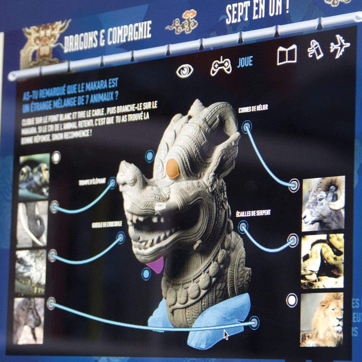 L'image semble représenter une interface interactive sur le thème des dragons, probablement liée à un jeu ou une présentation éducative. On y voit un dragon stylisé en trois dimensions, avec des informations interactives autour. Ces informations pourraient poser des questions ou fournir des faits sur les dragons et leur représentation dans la culture. Il y a aussi des images annexes qui enrichissent le contenu. Le fond est bleu, ce qui donne une ambiance fantastique à l'ensemble.