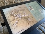 L'image montre un écran interactif qui présente une carte de l'Océanie. Sur la carte, plusieurs marqueurs sont disposés, probablement représentant des lieux d'intérêt ou des points historiques. À droite de l'écran, il y a un texte explicatif, tandis que le titre indique "Exploration Géographique" et "Exploration Maritime". Le fond de l'image semble être une pierre, suggérant que l'écran est installé dans un lieu historique ou un musée.
